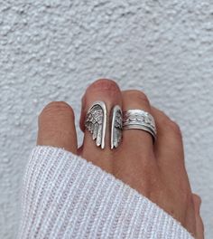 This antique silver boho statement ring features feathered angel wings which wrap around your finger as a sign of protection. Made from durable brass and coated with a thick layer of matte. Antique silver plate.  ▪️Adjustable design  ▪️Approx UK size L to P (US 6 - 8) ▪️Antique silver plated brass ▪️Will come presented in a cotton gift bag Care Instructions: ▪️Silver plate will last for years if looked after correctly ▪️Store in the protective gift bag to prevent tarnishing ▪️Keep away from wate Silver Winged Engraved Jewelry, Elegant Sterling Silver Winged Rings, Silver Engraved Wing-shaped Jewelry, Sterling Silver Angel Wing Ring, Angel Wing Ring, Boho Statement Ring, Feather Angel Wings, Nickel-free Sterling Silver Angel Wing Jewelry, Antique Silver Rings