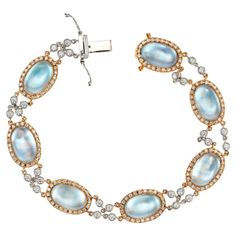 This unique bracelet by Designer JMP, begins with 7 oval cabochon light blue topaz set in 18k rose gold, each with a halo of round cut diamonds. The Topaz are connected by two rows of bezel set diamond links which are 18k white gold. The blue Topaz are mounted on Mother of Pearl. The bracelet measures at 7.25 inches in length. 189 round full cut Diamonds, approx. total weight 1.44cts, G – H, VS1 – SI1 7 Mother of Pearl backing 7 oval cabochon blue Topaz, approx. total weight 21.00cts, 11.44 x 7.13mm 18k rose and white gold 22.3 grams Tested and stamped: 18k Hallmark: JMP Length: 7.25 inches – Width: 10.42mm – Depth: 5.42mm Please Note, we photograph each item as accurately as possible. However, due to monitor/mobile device resolution and calibration, we understand some photos may vary in a Luxury Blue Oval Link Jewelry, Luxury Vintage Blue Topaz Jewelry, Diamond Gold Bracelet, Teal Jewelry, Modern Bracelets, Gold Armband, White Gold Bracelet, Bezel Set Diamond, Unique Bracelets