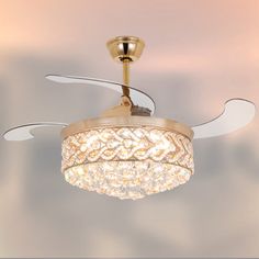 a gold ceiling fan with crystal chandelier hanging from it's center blade