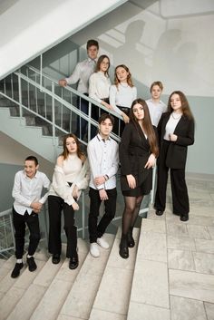 a group of young people standing on top of a stair case next to each other