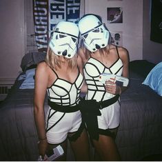 two women in star wars costumes standing next to each other with their faces painted like storm troopers