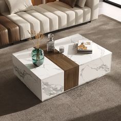 a modern coffee table with marble and wood in the middle, on carpeted living room floor