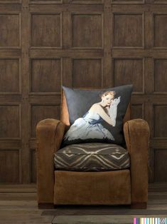 a chair with a pillow on it in front of a wooden paneled wall and floor