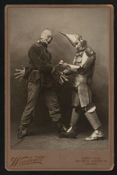 an old photo of two men dressed in costumes and holding hands out to each other