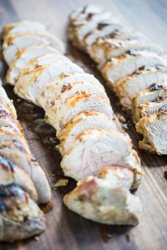 sliced meat sitting on top of a wooden cutting board