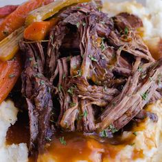 a close up of food on a plate with mashed potatoes and meat in gravy