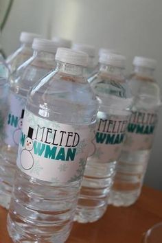 six bottled water bottles sitting on top of a wooden table