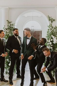 a group of men in tuxedos standing next to each other on a floor