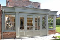 an orangery with glass doors and brick walls