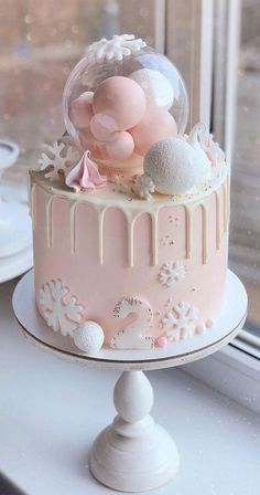 a pink and white cake sitting on top of a window sill