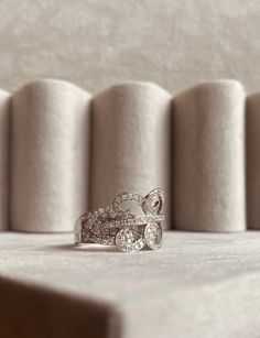 two wedding rings sitting on top of each other in front of rolls of toilet paper