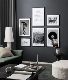 a living room with black walls and pictures on the wall, coffee table in front of it