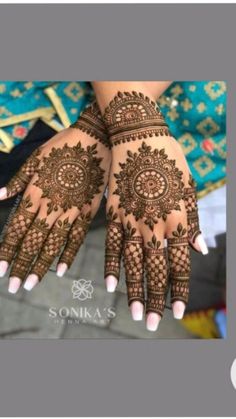 two hands with henna tattoos on them, one is showing off the intricate design