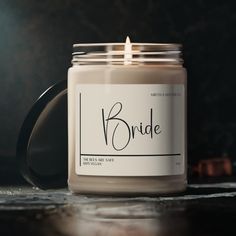 a candle with the word bride written on it sitting on a table next to some candles