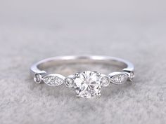 a white gold engagement ring with three stones on the side and an oval diamond in the middle