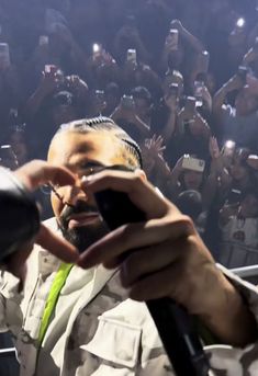 a man holding a cell phone in front of a crowd