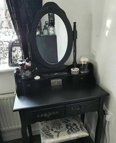 a black vanity with a mirror and stool