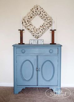 a blue cabinet with two candles on top