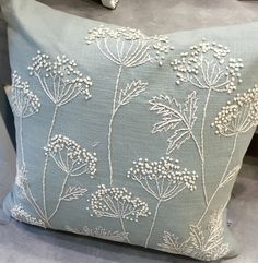 a blue pillow with white flowers on it