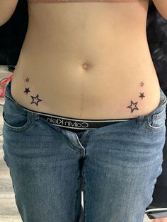 a woman's stomach with small stars on her belly and the word, cavin klin written in black ink