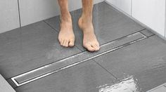 the legs of a person standing on a shower floor