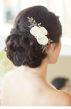 a woman wearing a wedding hair comb with flowers on it