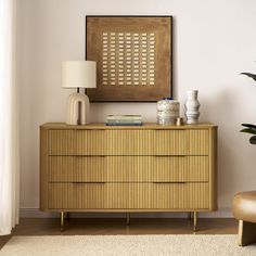 a wooden dresser sitting next to a lamp on top of a hard wood floor