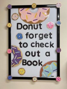 a sign with donuts on it that says, donut forget to check out a book