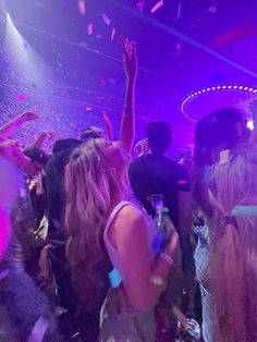 a group of people at a party with confetti thrown in the air above them