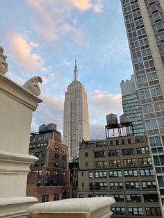 the empire building towering over new york city is seen in this view from an upper level balcony