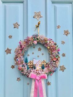 a wreath is hanging on the front door with pink ribbon and decorations around it,