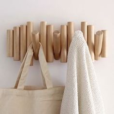 a tote bag sitting next to a wooden coat rack