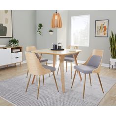 a dining room table with four chairs and a rug on the floor in front of it