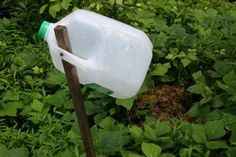 a plastic container with a wooden stick sticking out of it's side in the grass