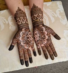 two hands with henna designs on them