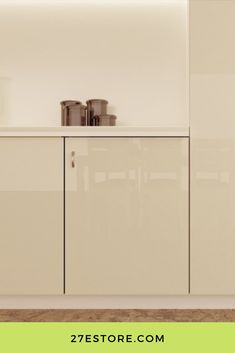 an empty kitchen with white cabinets and green border around the countertop, along with pots and pans