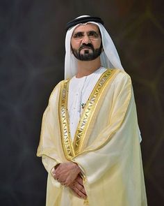 a man in a white and gold outfit standing with his hands on his hips while looking at the camera