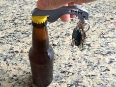 a beer bottle with a keychain attached to it sitting on top of a counter