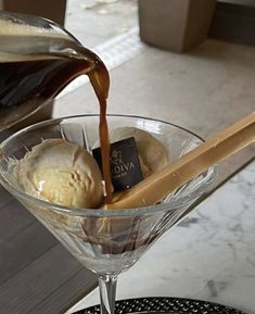 an ice cream sundae is being poured into a martini glass with chocolate and vanilla