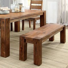 a wooden table with two benches in front of it on a carpeted floor next to a window