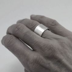 "This uniquely textured ring is hand forged from recycled sterling silver. The interior is satin smooth and polished for comfort, while the outside is hammered with a goldsmith's hammer to give it a bark-like texture. Each ring is unique. A great piece that can be dressy or casual. Made to order in ring sizes 5.5 to 14. The band is 3/8\" wide (10mm). Because wide bands require extra room to fit your finger properly please leave your actual ring size and I will adjust the size accordingly. Just s Minimalist Hammered Wide Band Ring, Minimalist Hammered Sterling Silver Wide Band Ring, Minimalist Hammered Silver Engraved Ring, Minimalist Silver Hammered Engraved Ring, Minimalist Silver Engraved Ring With Hammered Detail, Jewelry Recycled, Minimalist Silver Ring, Hammered Silver Ring, Wide Band Ring