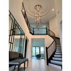 a large foyer with chandelier and stairs leading up to the second story door