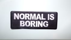 a black and white patch that says normal is boring