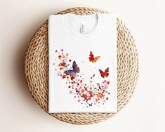 Embrace nature with this adorable floral butterflies t-shirt! Featuring a beautiful design of colorful flowers and vibrant butterflies, this cute t-shirt is perfect for women who love nature and animals. Made from soft, high-quality fabric, this t-shirt offers comfort and style for any casual occasion. The image on this t-shirt was created with artificial intelligence. This classic unisex jersey short sleeve tee fits like a well-loved favorite. Soft cotton and quality print make users fall in lo Cute Butterfly Print T-shirt For Spring, White Butterfly T-shirt For Spring, White Butterfly T-shirt For Summer, Cute Spring Butterfly Print T-shirt, Multicolor Tops For Spring As A Gift, Multicolor T-shirt For Spring Gift, Floral Print T-shirt For Spring Gift, Floral Print T-shirt As A Spring Gift, Floral Print T-shirt For Spring