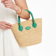 Inspired by a recent trip to Italy, the Mia Handbag is a beautiful bag for summer days, wedding celebrations or any time you need a touch of luxury. Its beauty is in its simplicity: handwoven raffia meets soft and supple Italian leather. This unlined open tote instantly evokes long summer days on the Italian countryside. Add a foil debossed monogram for a personal touch.    7.5"w (bottom), 13.5"w (top) x 4.75"d x 10"h  Handle drop: 4"  Handwoven raffia, Italian leather.  Clean with a soft cloth. Elegant Natural Straw Bag For Shopping, Elegant Natural Straw Shopping Bag, Elegant Beach Bag With Leather Handles For Vacation, Chic Handheld Crochet Bag In Natural Color, Elegant Natural Straw Tote Bag, Chic Natural Handheld Crochet Bag, Elegant Top Handle Beach Bag For Vacation, Elegant Straw Bag With Double Handle For Vacation, Elegant Straw Bag With Double Handles