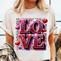 a woman wearing a t - shirt with the word love painted on it and hearts