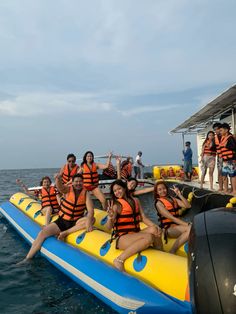 a group of people riding on top of rafts in the ocean next to a boat