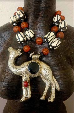 This rare and scarce tribal statement necklace is new and unworn from my private collection. It features a very hard to find Tibetan Repousse Camel pendant with inlaid black onyx and red carnelian. I remain uncertain about the small gold metal spor at the 11 o'clock position in the onyx, but I purchased the stone like this. The camel is as ornate on the back as it is on the front, and measures a lightweight 5.25" x 5" (the camel is hollow). The adjustable double strand beaded necklace ranges fro Artisan Black Ceremonial Jewelry, Artisan Black Jewelry For Festivals, Black Bohemian Necklace For Ceremonial Occasion, Traditional Black Necklaces With Large Pendant, Bohemian Black Carved Necklace, Traditional Black Necklace With Large Pendant, Jewellery Shop Design, Turquoise Western, Red Carnelian