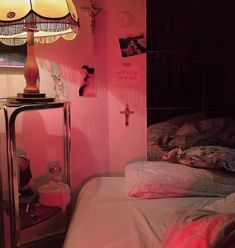 a bedroom with pink walls and a bed in the corner, next to a lamp