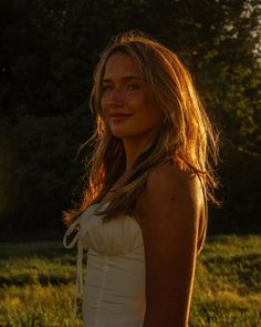 a beautiful young woman standing in the grass